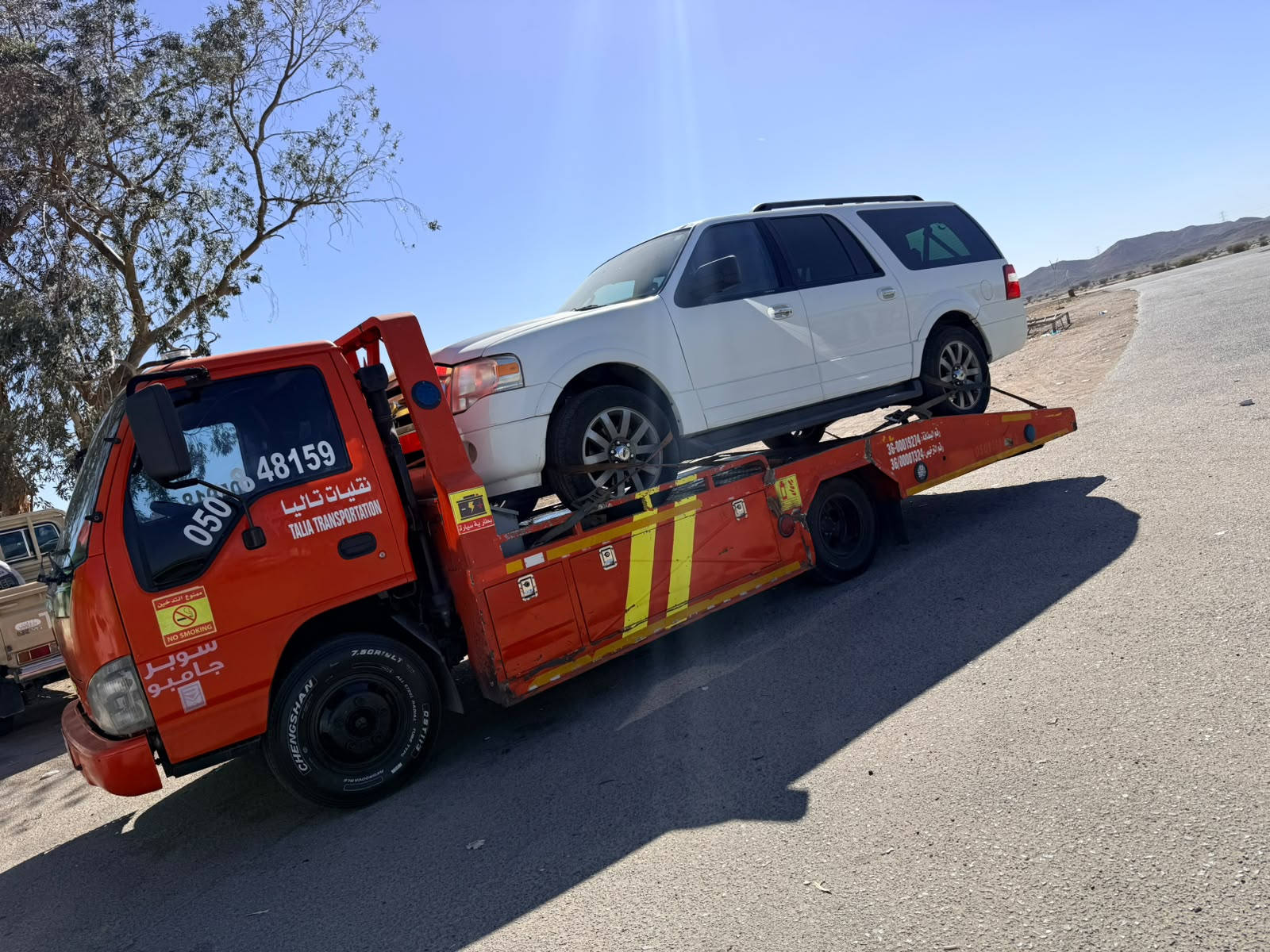 سطحة ضباء تنقل فورد إكسبيديشن بيضاء على طريق تبوك